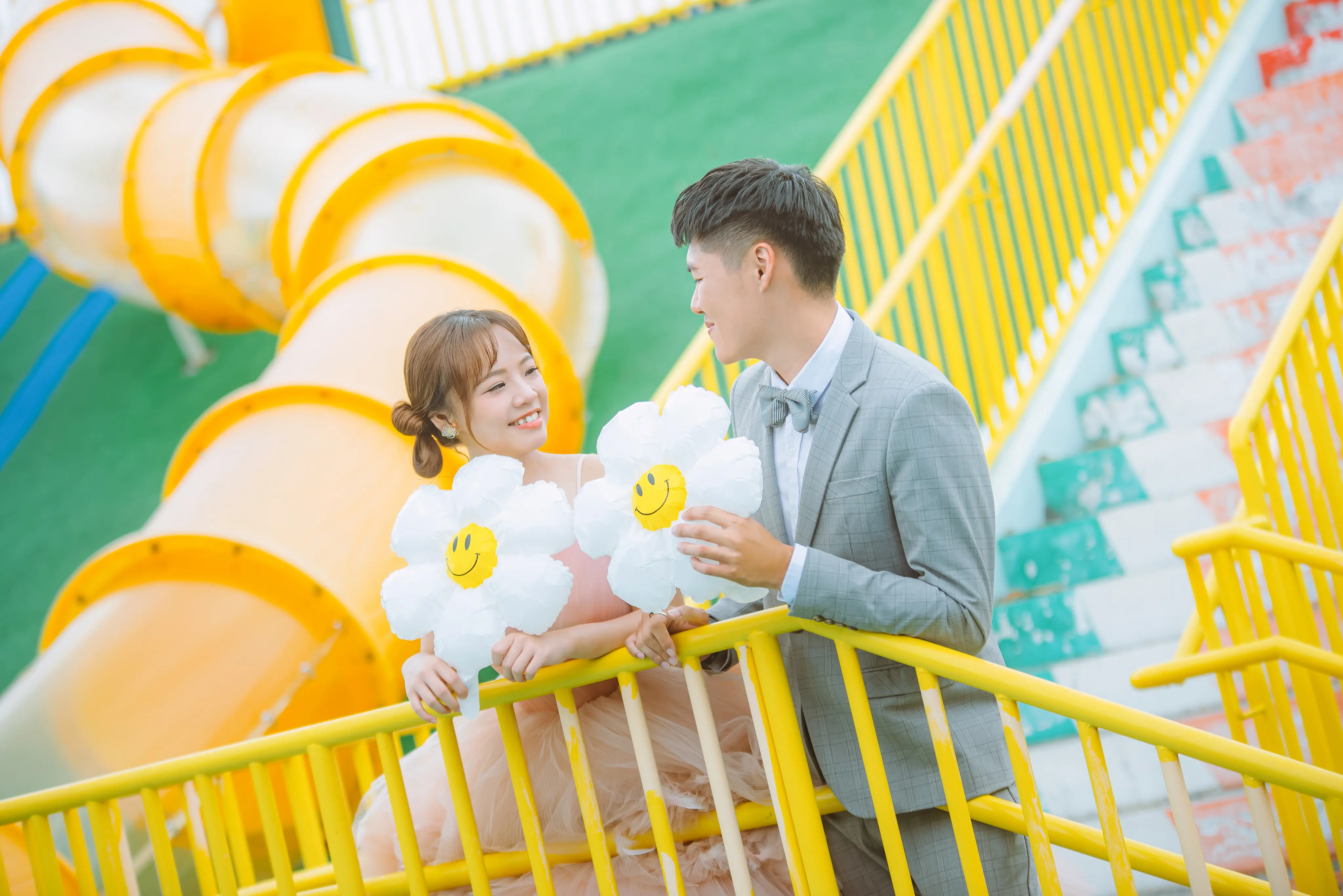 高雄婚紗攝影：新人穿粉色禮服與西裝，在繽紛階梯前互動