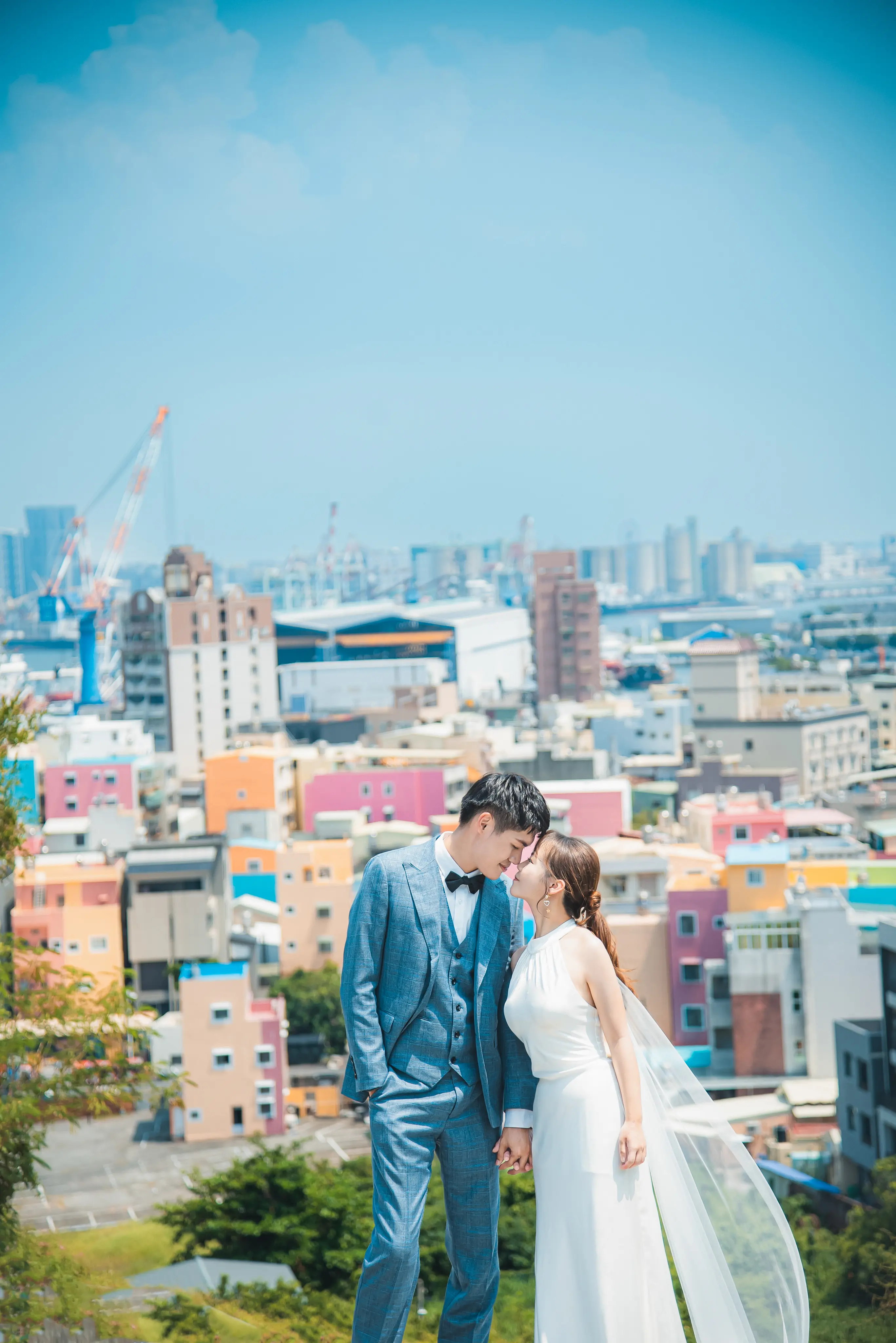 高雄婚紗攝影：新人穿白紗與藍色西裝，在城市高處相依
