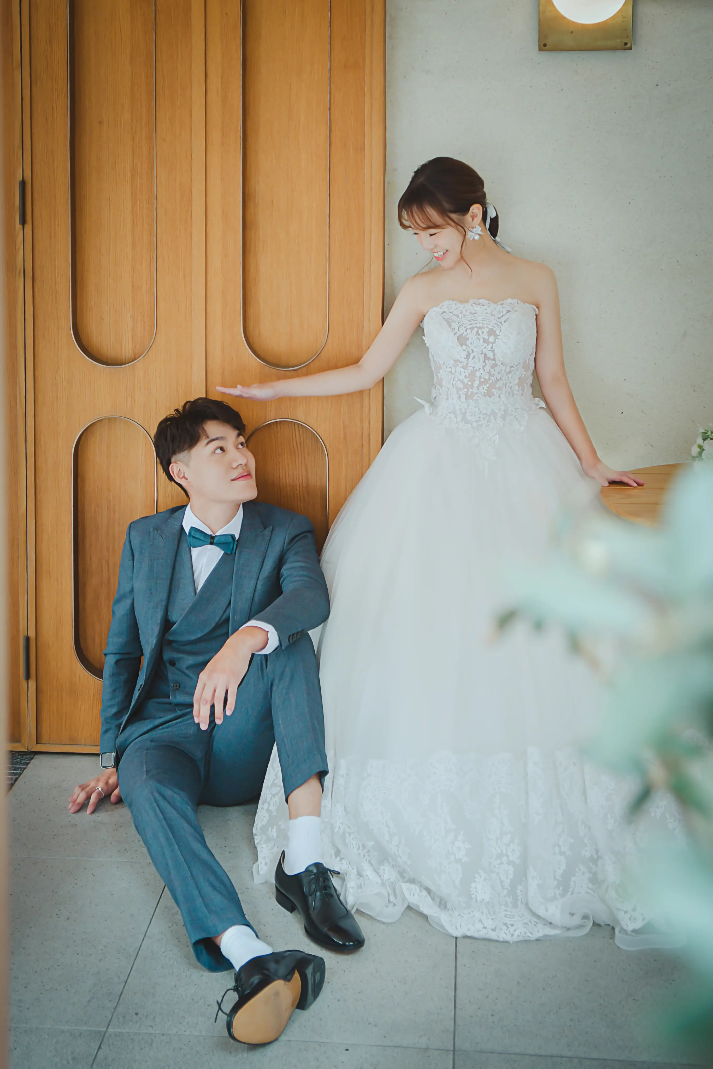 高雄婚紗攝影：新郎坐在木質門旁，新娘穿蓬裙白紗站在身側