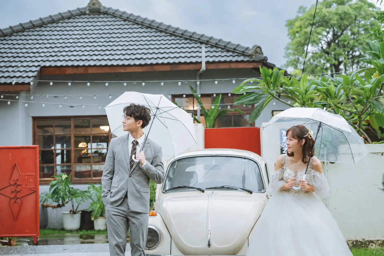 新人各自撐著透明雨傘，站在復古白色汽車兩側