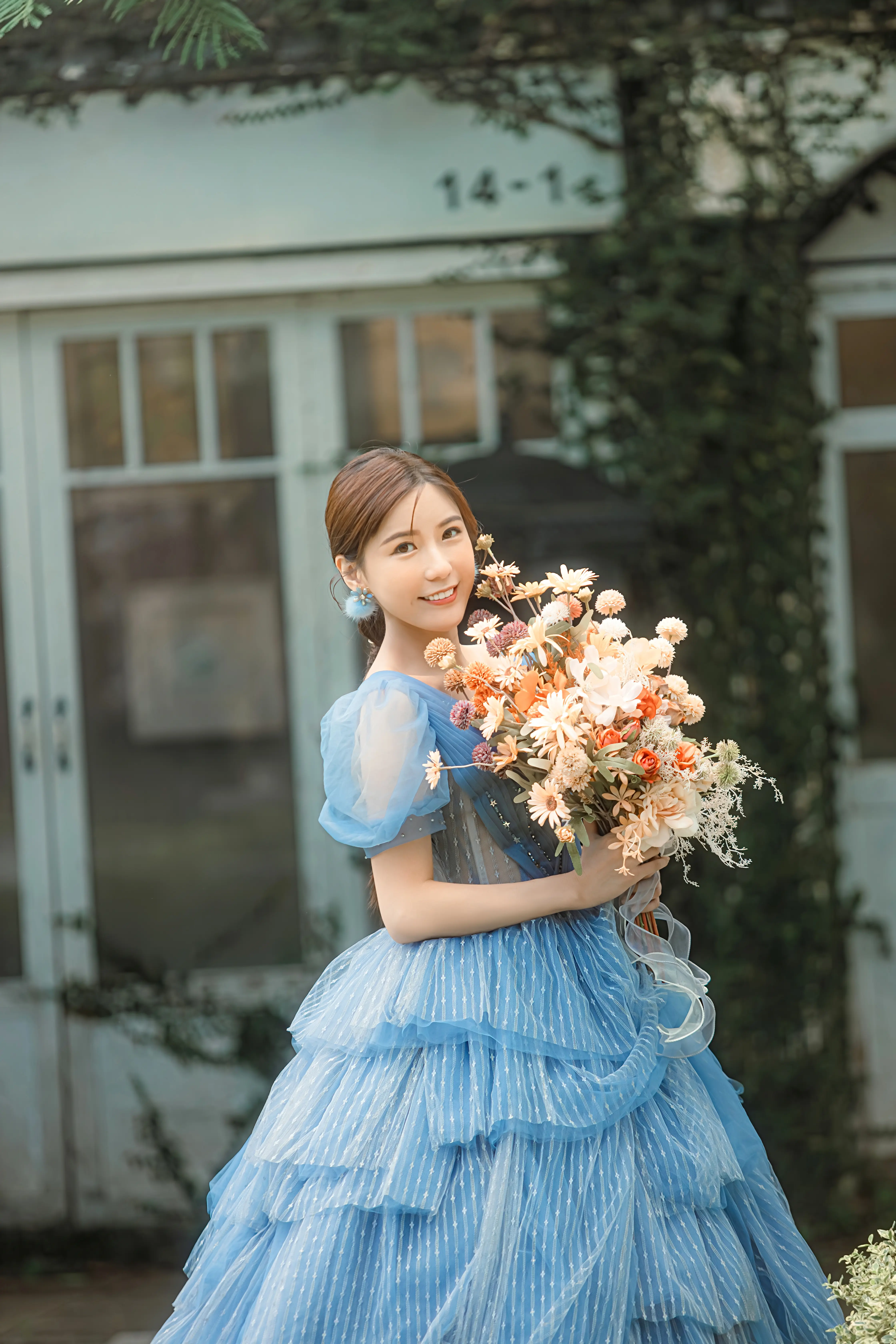穿藍色禮服的新娘手捧花束拍攝戶外單人婚紗照