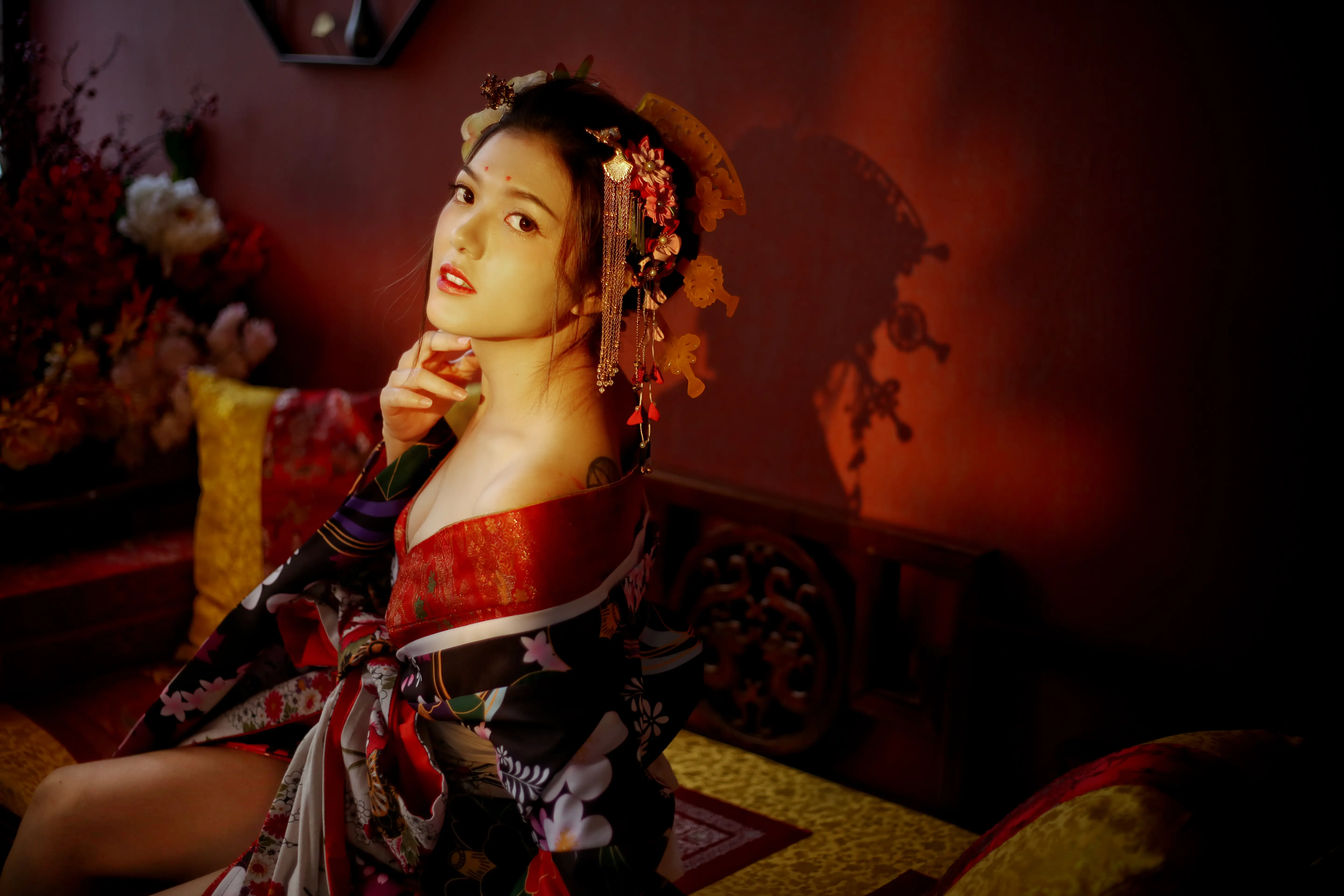 身穿紅黑色華麗花魁服飾的新娘，在暖色燈光下拍攝個人造型照